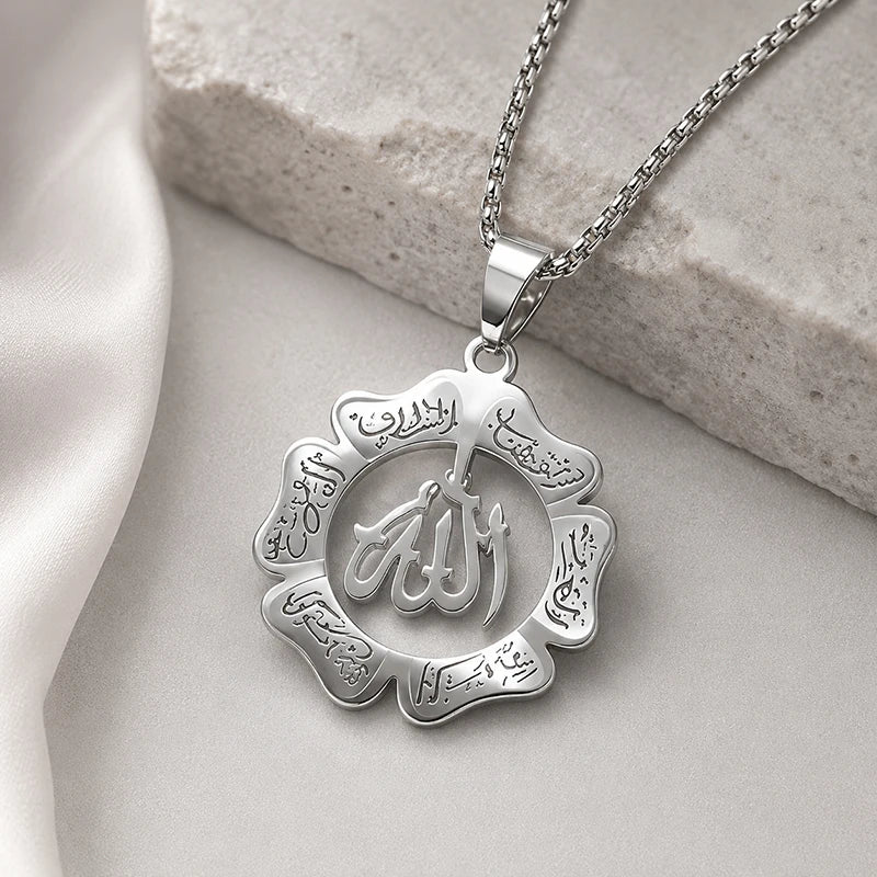 Silver pendant necklace featuring the Arabic calligraphy of Ayatul Kursi on a smooth, light-colored stone background.