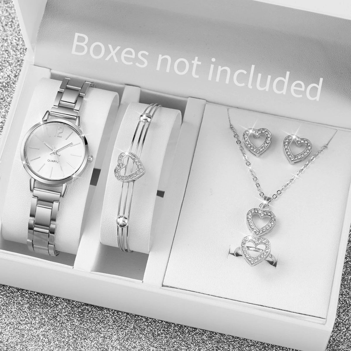 A white box shows a quartz wrist watch, a silver bracelet, and a silver necklace with heart pendants.