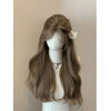 A long, wavy brown wig displayed on a mannequin with a white floral accessory.