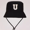 Black sun hat with a white letter U embroidered on the front and an adjustable cord.