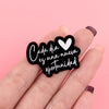 Pin de solapa de esmalte negro con corazón blanco y texto que dice Cada día es una nueva oportunidad