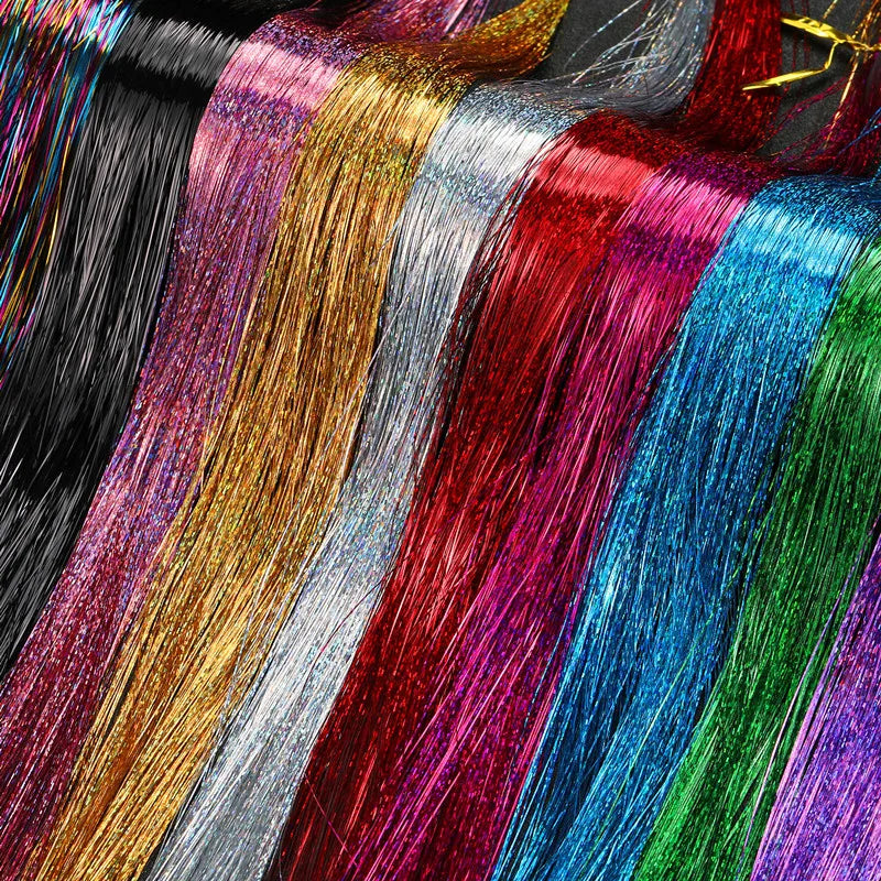 A close-up display of twelve strands of vibrant synthetic hair tinsel in various colors like gold, silver, red, blue, and gre