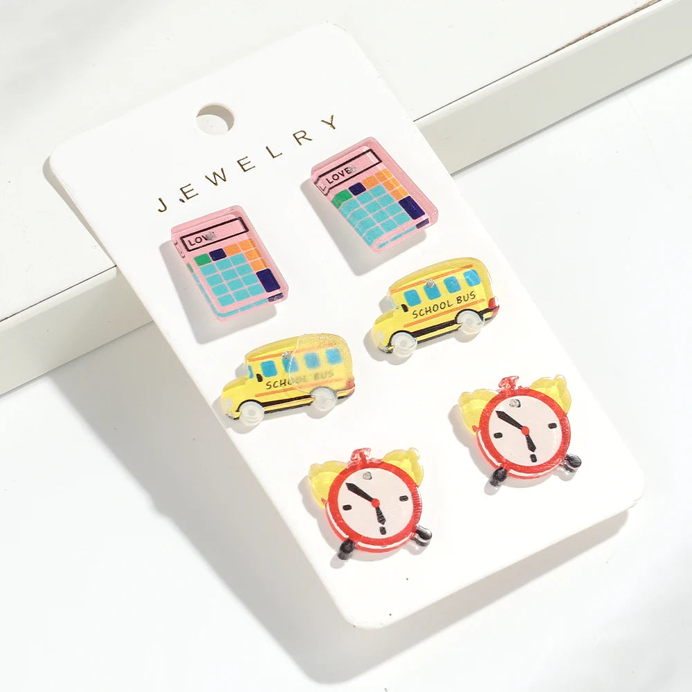 Un tarjeta blanca mostrando aretes de lápiz de colores de varios colores, incluyendo un patrón de cuadrícula y un diseño de a