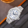 A silver-toned Riccetto quartz wristwatch with a white dial and date display resting on a gray fabric.