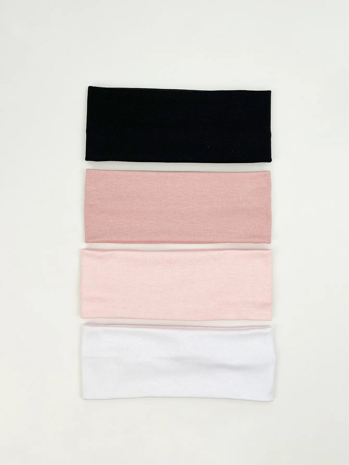 A set of four knitted hair bands in black, pink, and white.