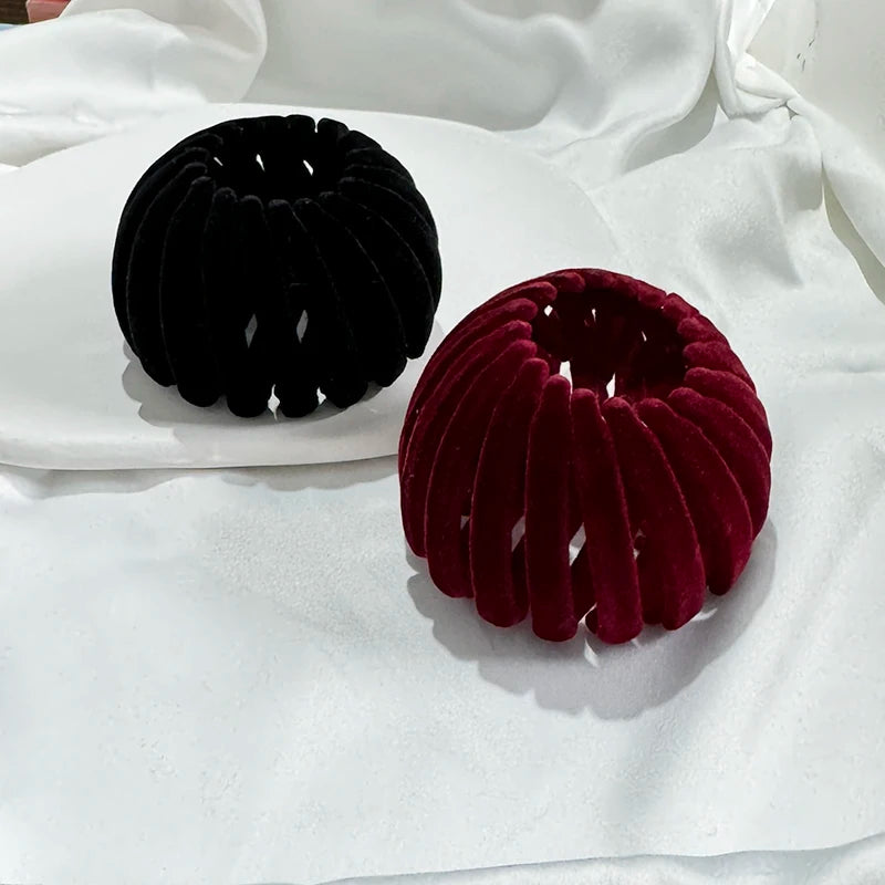 A pair of elegant horsetail hair clips in black and deep red velvet are displayed on a white surface.
