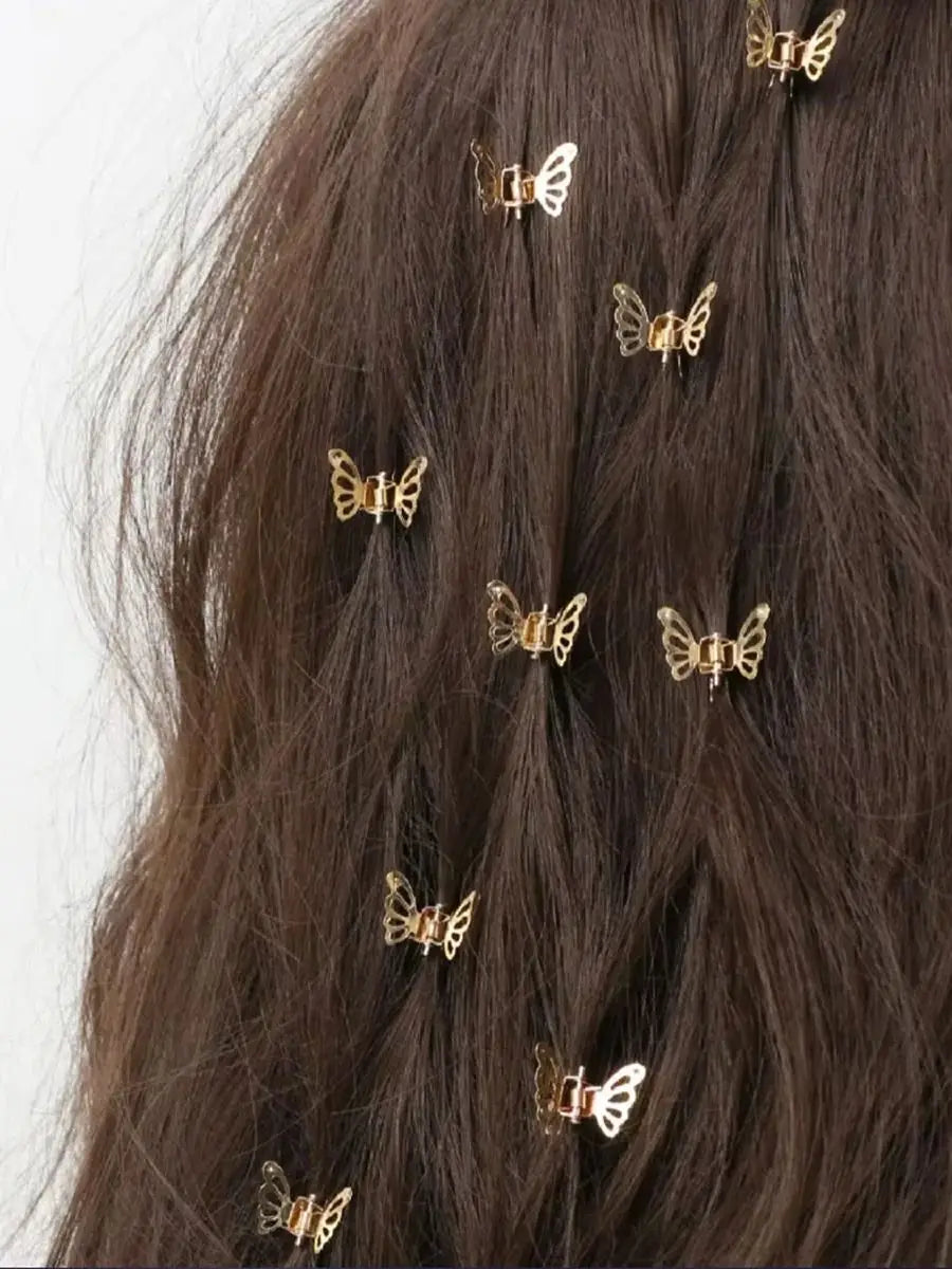 A close-up of dark brown hair adorned with ten small gold metal butterfly hair clips.
