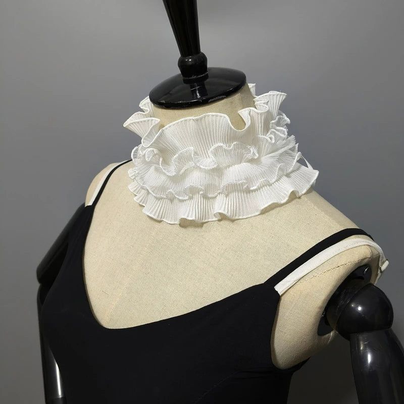A black sweater displayed on a mannequin featuring a white pleated ruffle stand collar.