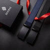 A black tactical canvas utility belt with a blue woven strap and red ribbon is displayed on a dark surface.