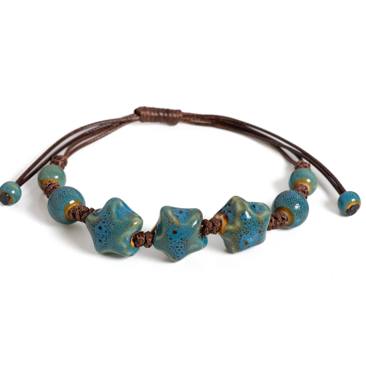 A handmade glazed ceramic star bracelet with blue-green and brown beads on a leather cord.