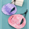Un chapeau pour animaux de compagnie violet pour chiens et chats à côté d'un rose sur fond bleu clair.