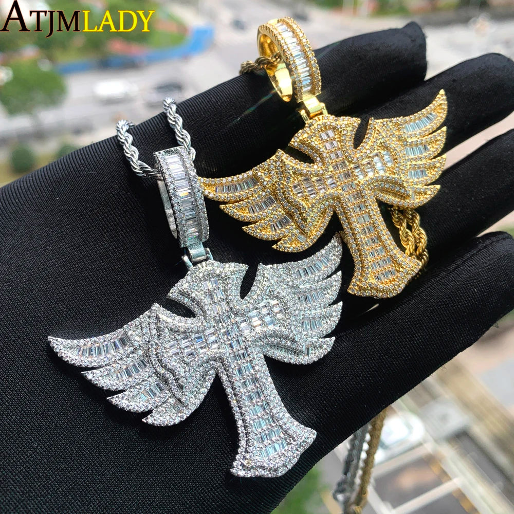 Un pendentif de croix en or et argent serti est exposé sur une main noire.