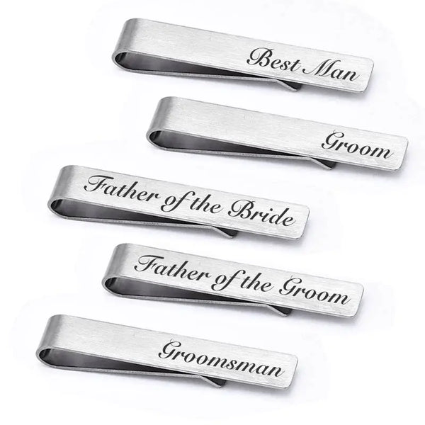 A set of five brushed stainless steel men's tie clips engraved with titles like Best Man, Groom, Father of the Bride, etc.