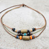 A set of boho vintage wood and stone bead necklaces on a brown leather cord.