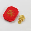 A red felt tag with a gold circular emblem and a small gold turtle charm.