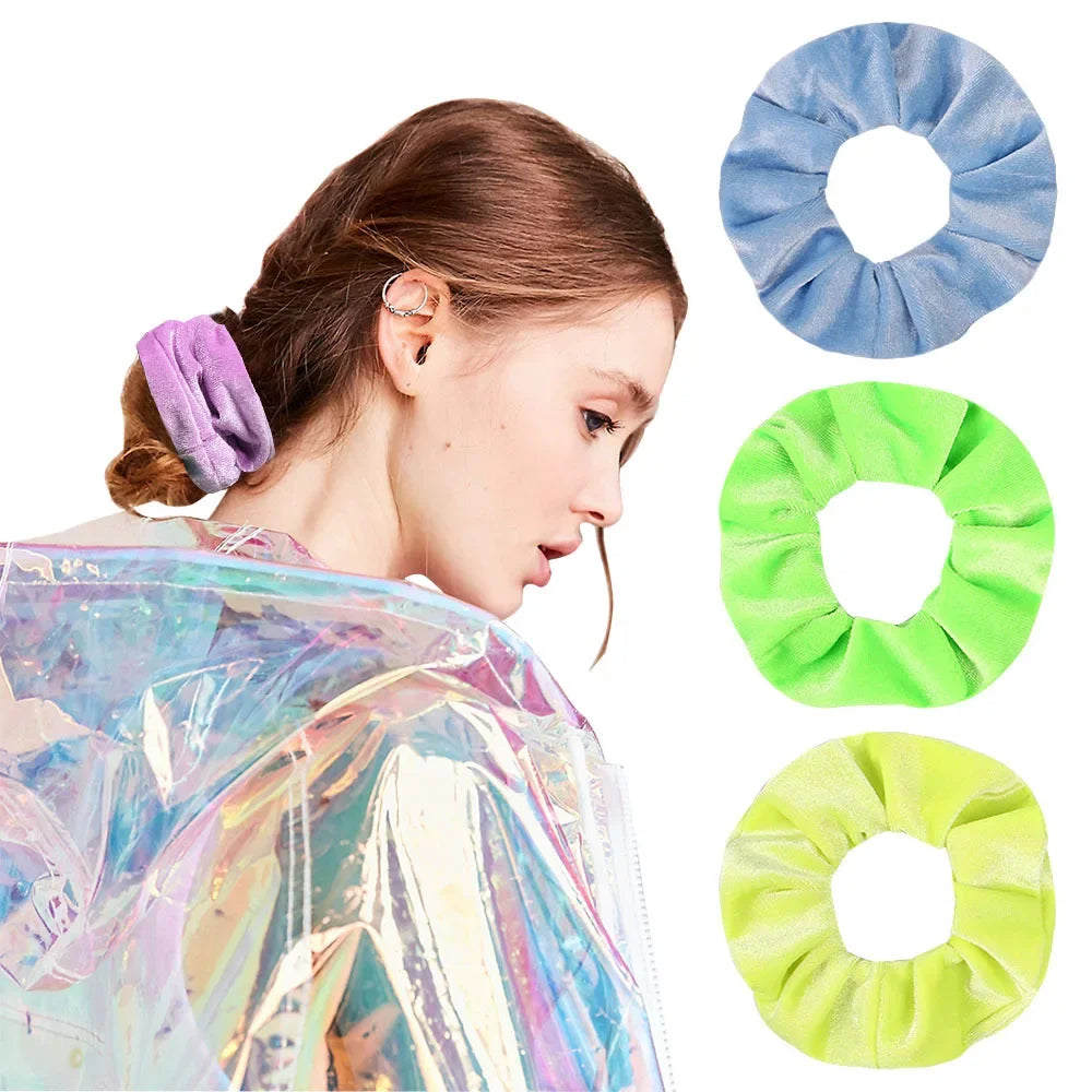 A woman is shown wearing a purple velvet scrunchie on her hair, with other colored scrunchies displayed nearby.