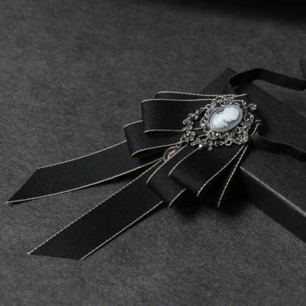 Nœud papillon noir avec fermoir en strass et pierre ovale blanche.