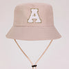 A beige sun hat for kids featuring a gold letter A embroidered on the front.