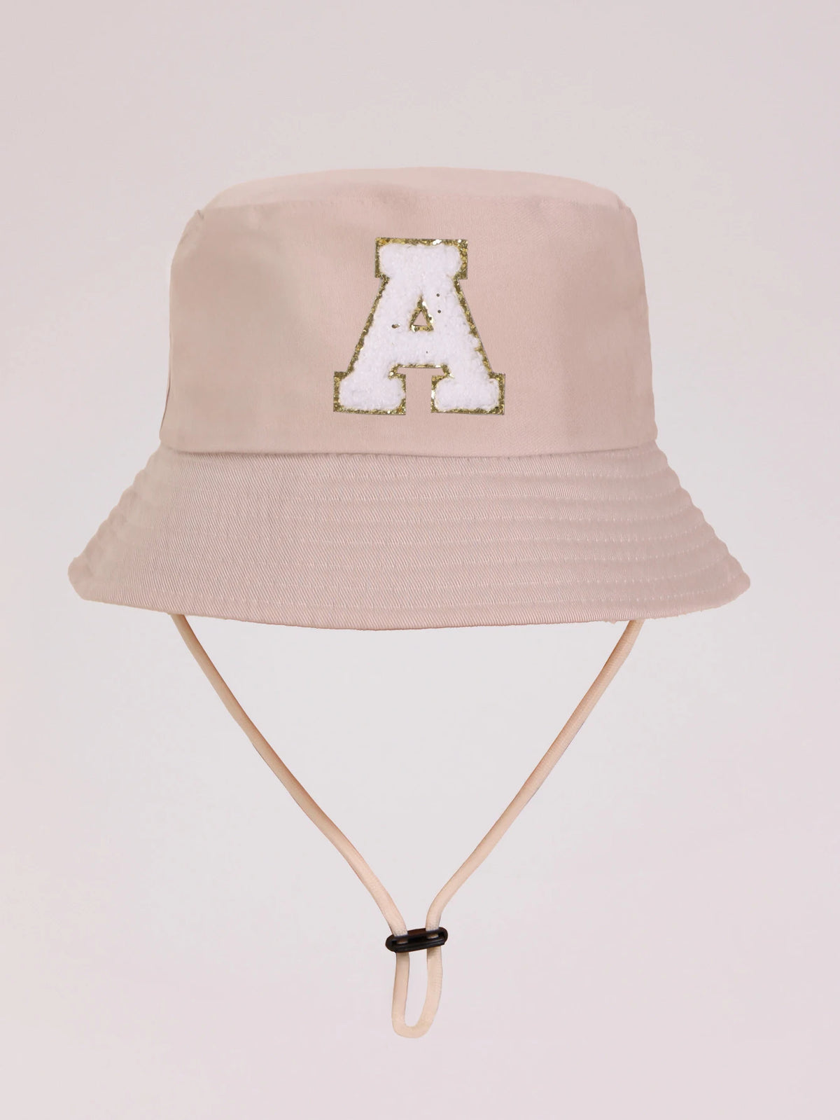 A beige sun hat for kids featuring a gold letter A embroidered on the front.