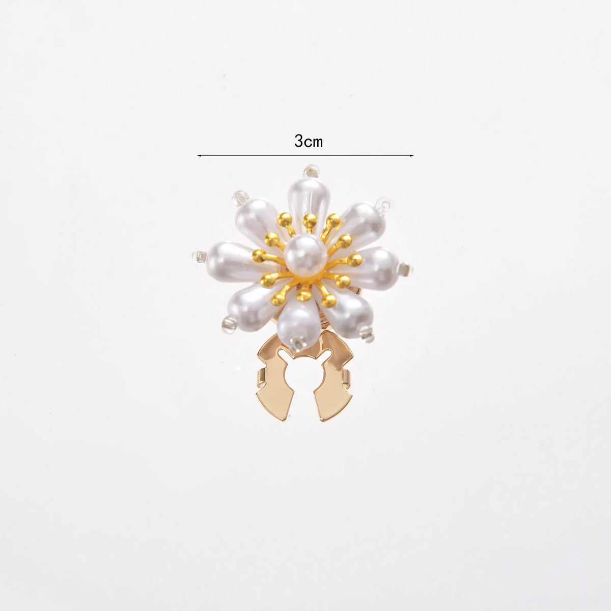 A floral button cufflink featuring white pearls and gold accents.