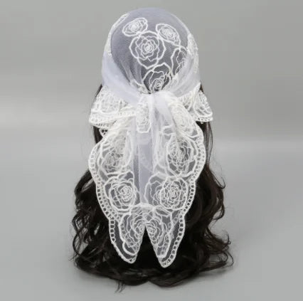 White floral embroidered lace bandana headscarf tied around dark hair