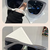A pair of gray cat eye sunglasses with dark lenses and a light green detail are shown on a white surface.