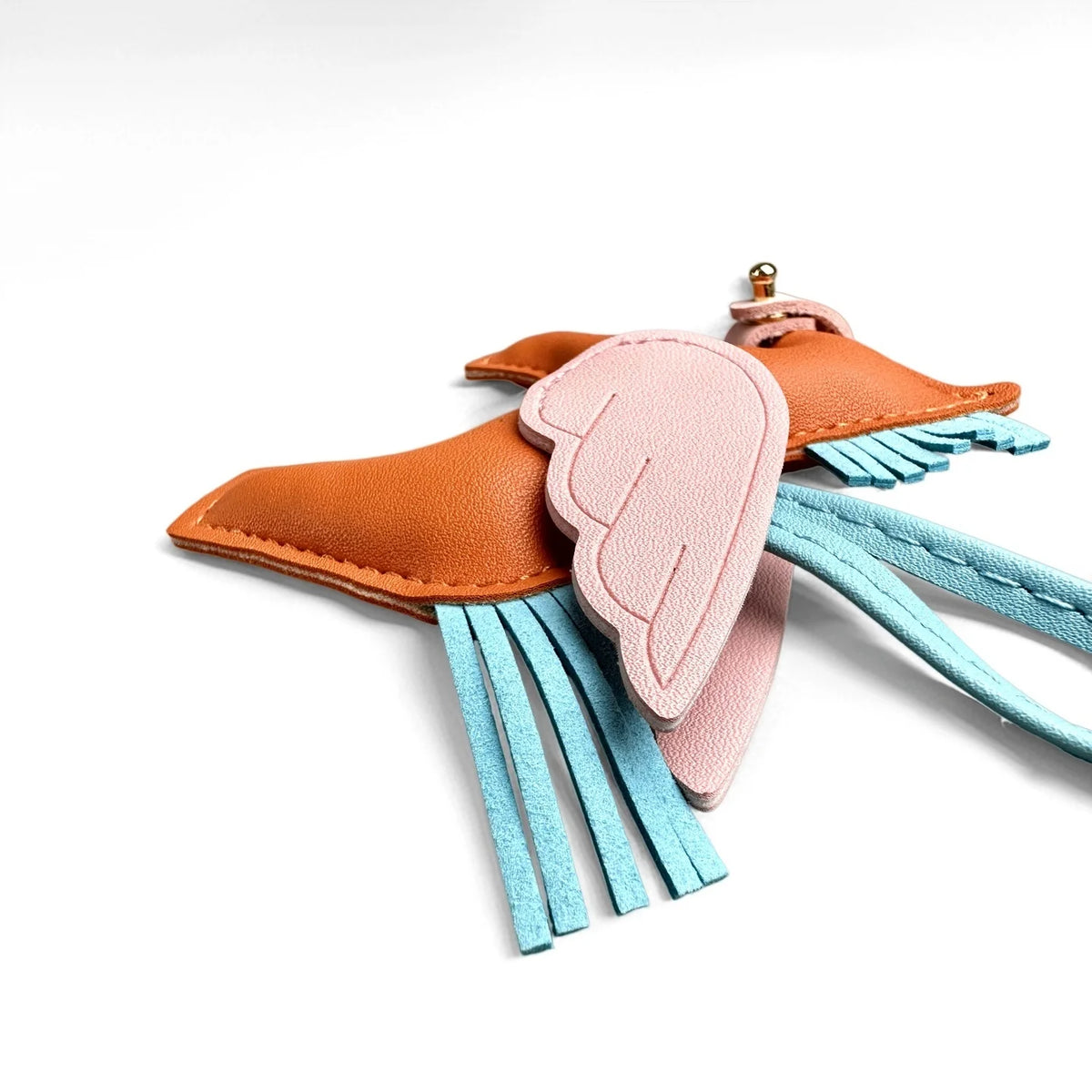 An elegant winged pony keychain featuring a leather ear and pink feather with teal fringe.