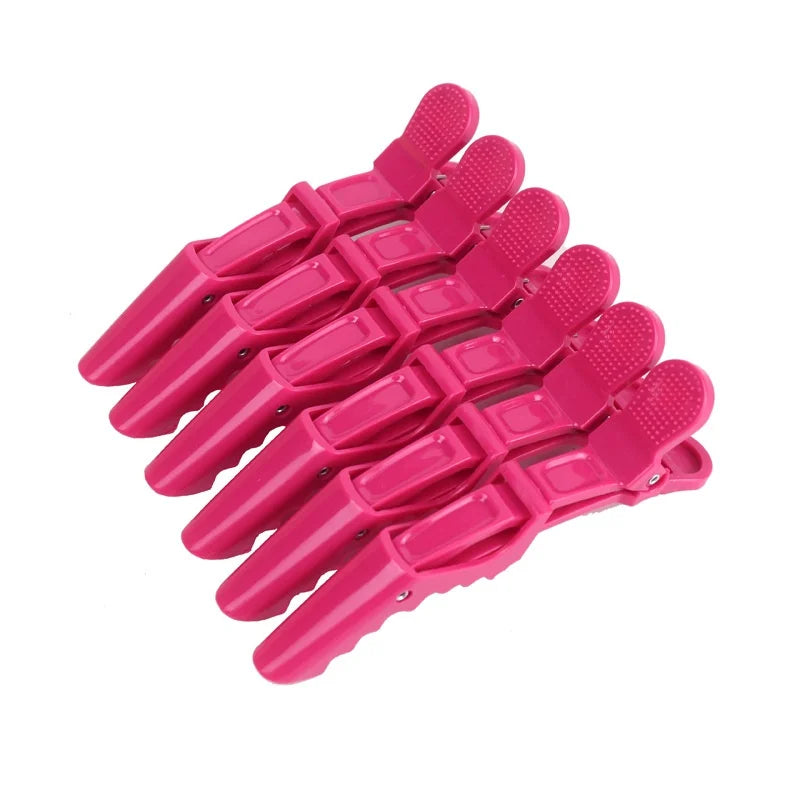 A set of six pink alligator hair sectioning clips arranged in a fan shape.