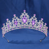 An elegant crystal rhinestone tiara and headband set featuring purple gemstones.