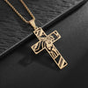 A gold-toned retro Christian cross amulet necklace with a detailed design is displayed on a dark surface.
