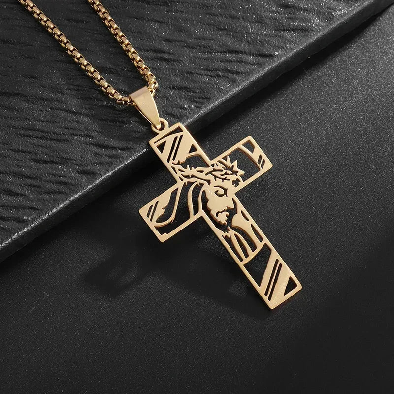 A gold-toned retro Christian cross amulet necklace with a detailed design is displayed on a dark surface.
