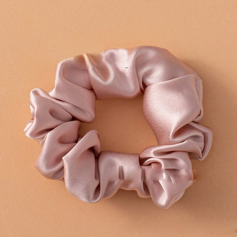 Primer plano de una cinta para el cabello de seda morada suave y rosa atada en forma de lazo delicado.