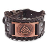 A dark brown leather bracelet with a bronze compass design and a buckle.