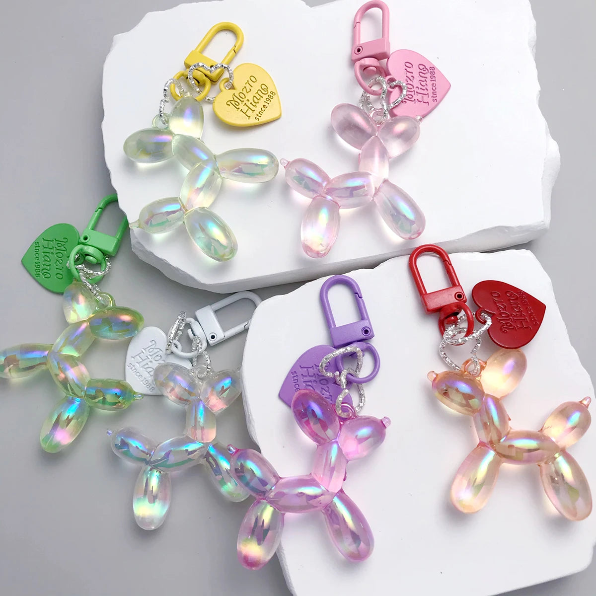 A collection of sweet resin animal dog keychains in various colors and shapes displayed on a white surface.