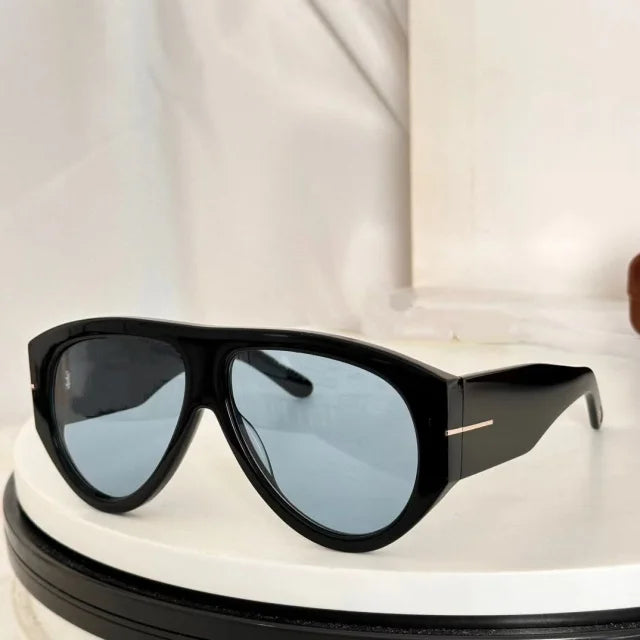 Black oversized pilot sunglasses with dark blue lenses resting on a white surface.