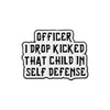 White enamel lapel pin with black text that reads Officer I drop kicked that child in self defense