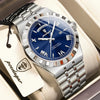 A silver-toned men's watch with a blue dial and metal bracelet is displayed in a box.
