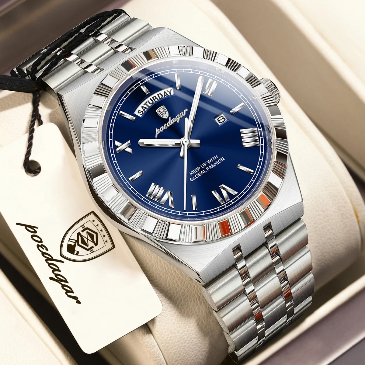 A silver-toned men's watch with a blue dial and metal bracelet is displayed in a box.