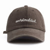 A dark gray baseball cap with white embroidered text that reads overstimulated