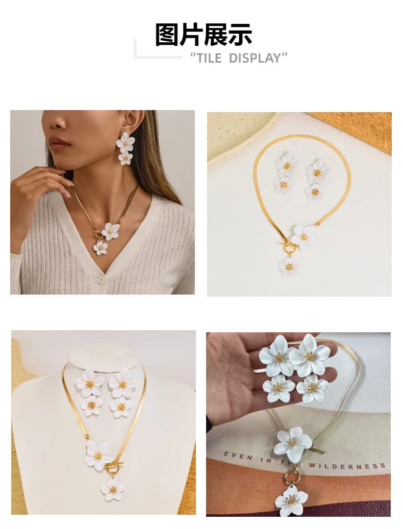A gold-toned floral pendant necklace and matching earrings set displayed on a white background.