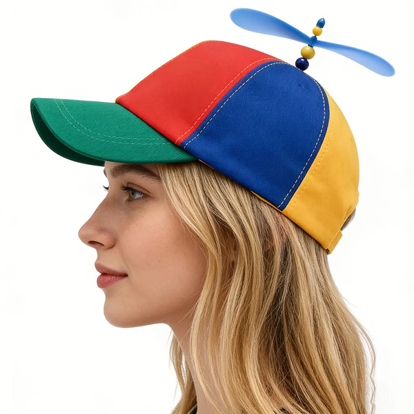 A woman wearing a funny multicolor propeller hat with red, blue, and yellow panels.