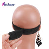A hand holds a black elastic wig band for hair edges, displayed against a mannequin head.