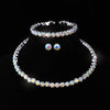 A set of four crystal jewelry pieces including a bracelet, necklace, and earrings displayed against a black background.