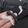 A hand holds a pair of clear silicone anti-slip ear hooks designed for eyewear.
