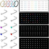 A set of stainless steel nose studs and body piercing jewelry in various colors and styles.
