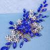 A delicate accessory featuring blue gemstones and clear pearls arranged in a floral design for hair.