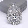 Broche florale en cristal élégante avec un grand diamant central entouré de pierres claires scintillantes.