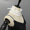 A black sweater displayed on a mannequin featuring a white pleated ruffle stand collar.