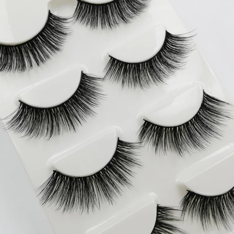 A set of handmade mink strip eyelashes displayed on a white plastic tray.