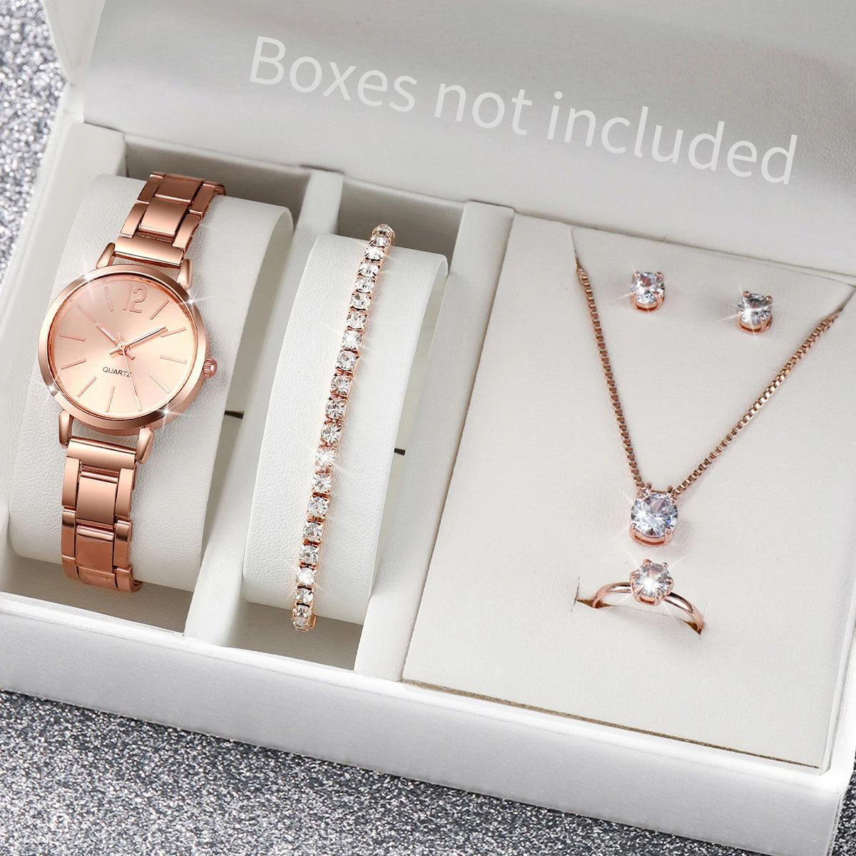 A box containing a rose gold quartz wrist watch, a diamond necklace, and a ring.